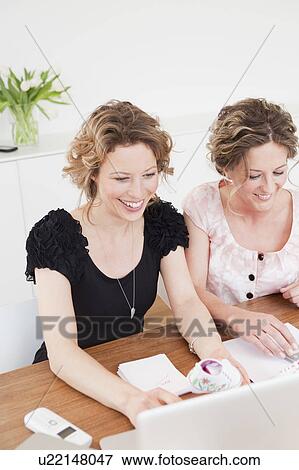 Stock Photo - Two woman working together. Fotosearch