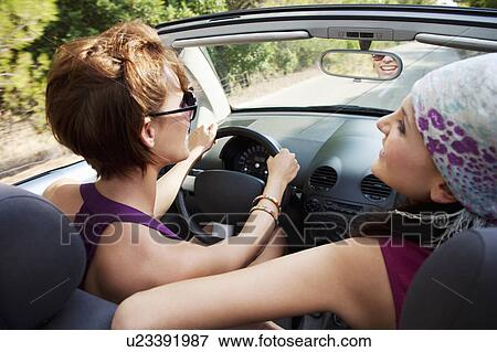 Two women in convertible car in the sun View Large Photo Image Stock Photo - Two women in convertible car in the sun. Fotosearch