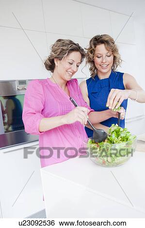 Two women preparing green salad together View Large Photo Image Stock Photograph - Two women preparing green salad together. Fotosearch