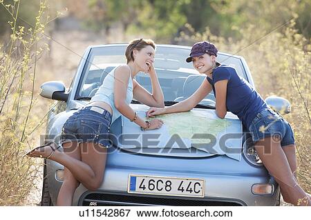 Two women reading a map on a car bonnet View Large Photo Image Stock Photo - Two women reading a map on a car bonnet. Fotosearch
