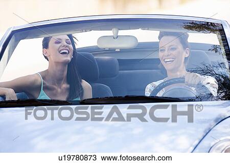 Two women smiling in a car View Large Photo Image Stock Image - Two women smiling in a car. Fotosearch