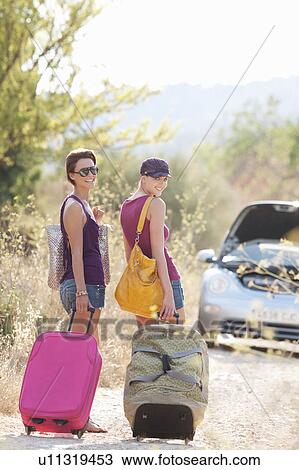Two women walking along a country lane View Large Photo Image Stock Image - Two women walking along a country lane. Fotosearch