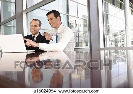 Two young business men using laptop View Large Photo Image Picture - Two young business men using laptop. Fotosearch