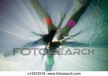 Stock Photograph - Underwater shot of synchronised swimmers. Fotosearch
