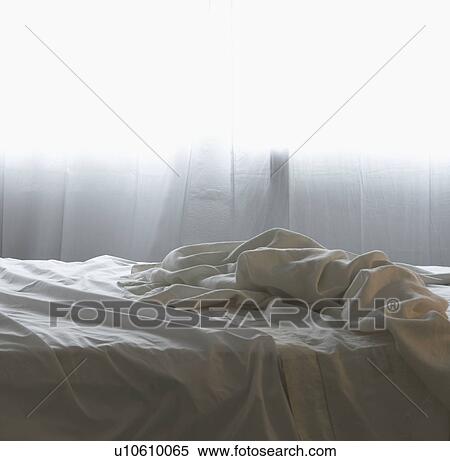 Stock Photography - Unmade bed in morning light. Fotosearch