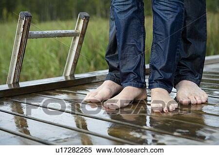 Stock Photography - Wet feet of a couple on a dock. Fotosearch
