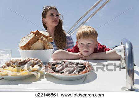 Woman and boy eating lunch on yacht View Large Photo Image Stock Image - Woman and boy eating lunch on yacht. Fotosearch