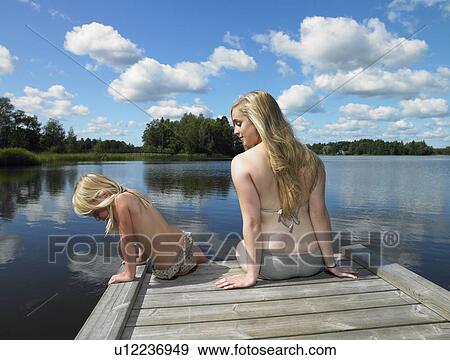 Woman and girl in swimsuit, on a dock View Large Photo Image Stock Photo - Woman and girl in swimsuit, on a dock. Fotosearch