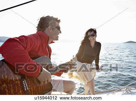 Woman and Man playing guitar on yacht View Large Photo Image Stock Image - Woman and Man playing guitar on yacht. Fotosearch