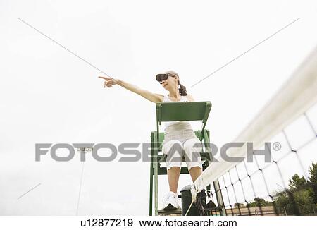Stock Photo - Woman as umpire on tennis court. Fotosearch