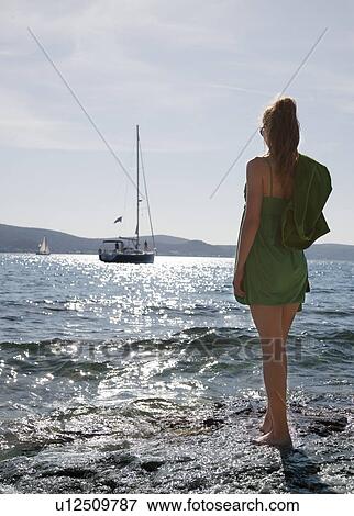 Woman at beach looking at yacht View Large Photo Image Stock Photo - Woman at beach looking at yacht. Fotosearch