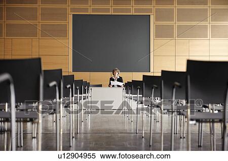 Woman at head of empty conference hall View Large Photo Image Stock Photography - Woman at head of empty conference hall. Fotosearch