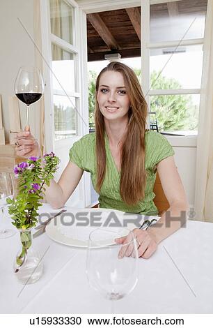 Stock Image - Woman at restaurant drinking wine. Fotosearch