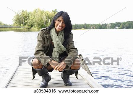 Woman at the end of a dock, smiling View Large Photo Image Stock Photograph - Woman at the end of a dock, smiling. Fotosearch