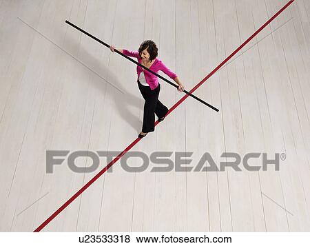 Stock Photo - Woman balancing on thin red line. Fotosearch