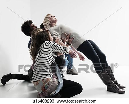 Stock Image - Woman being supported by 4 people. Fotosearch