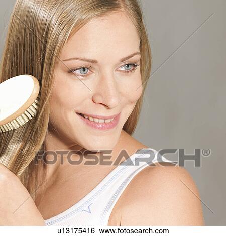 Woman brushing her hair View Large Photo Image Stock Photograph - Woman brushing her hair. Fotosearch