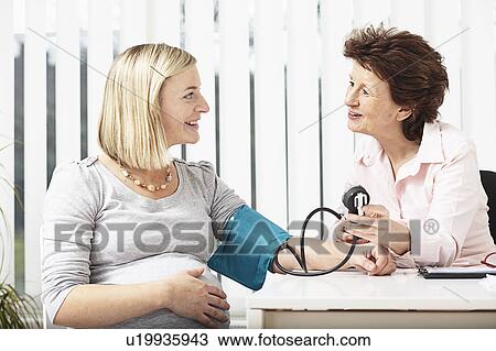 Stock Image - Woman consulting pregnant woman. Fotosearch