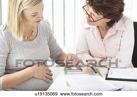 Woman consulting pregnant woman View Large Photo Image Stock Photo - Woman consulting pregnant woman. Fotosearch