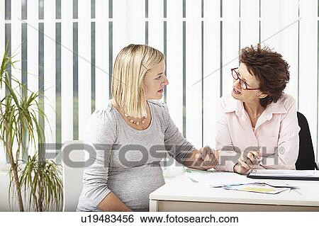 Stock Photograph - Woman consulting pregnant woman. Fotosearch