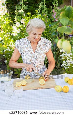 woman cutting lemons for lemonade View Large Photo Image Stock Photography - woman cutting lemons for lemonade. Fotosearch