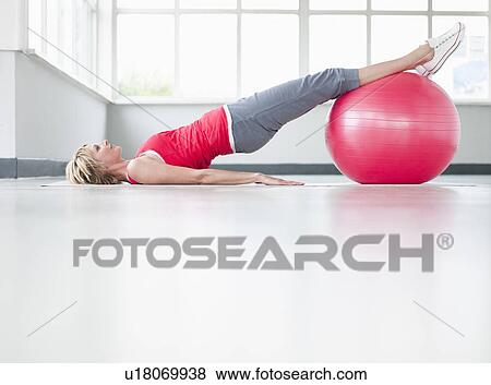 Woman doing leg exercise with gymball View Large Photo Image Stock Photo - Woman doing leg exercise with gymball. Fotosearch