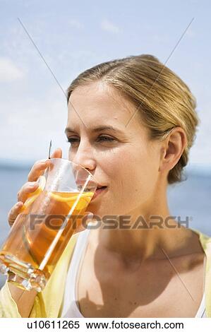 Stock Photography - Woman drinking an iced tea. Fotosearch