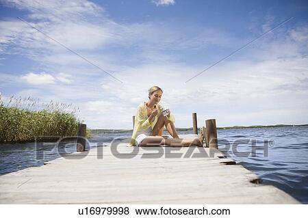 Woman eating a yogurt View Large Photo Image Stock Photo - Woman eating a yogurt. Fotosearch