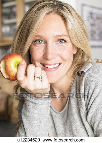 Woman eating an apple View Large Photo Image Stock Photo - Woman eating an apple. Fotosearch