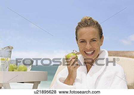 Woman eating an apple View Large Photo Image Stock Photo - Woman eating an apple. Fotosearch