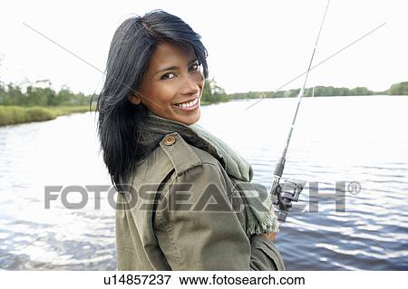 Stock Photo - Woman fishing, smiling at camera. Fotosearch