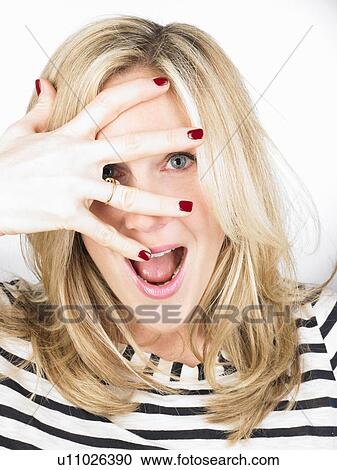 Stock Image - Woman hiding her eyes with her hand. Fotosearch