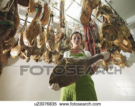 Stock Photography - Woman holding a ham leg. Fotosearch