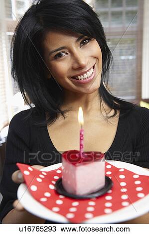 Stock Image - Woman holding a heart shaped cake. Fotosearch