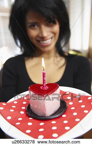 Stock Photo - Woman holding a heart shaped cake. Fotosearch