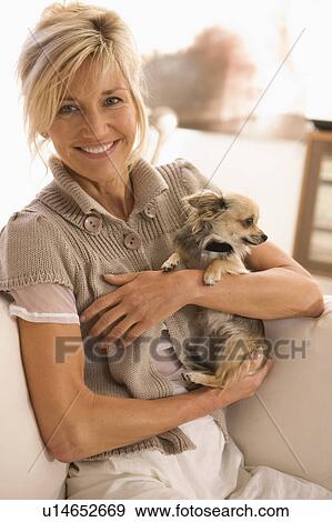 Woman holding a little dog in her arms View Large Photo Image Stock Photo - Woman holding a little dog in her arms. Fotosearch
