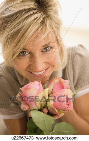 Stock Image - Woman holding flowers in her hands. Fotosearch