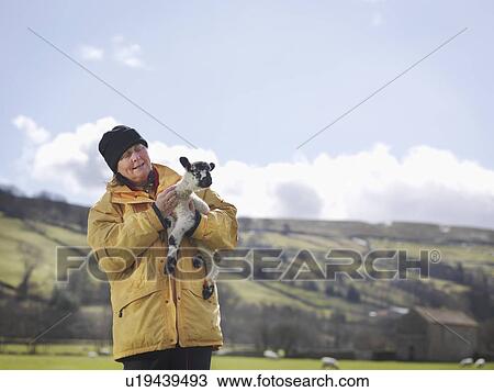 Stock Image - Woman holding lamb. Fotosearch