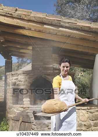 Woman holding shovel with bread loaf View Large Photo Image Stock Photo - Woman holding shovel with bread loaf. Fotosearch