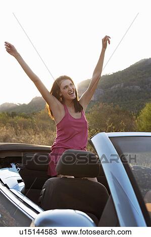 Woman in car with arms in the air View Large Photo Image Stock Image - Woman in car with arms in the air. Fotosearch