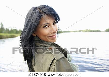 Stock Photo - Woman in front of a lake, smiling. Fotosearch