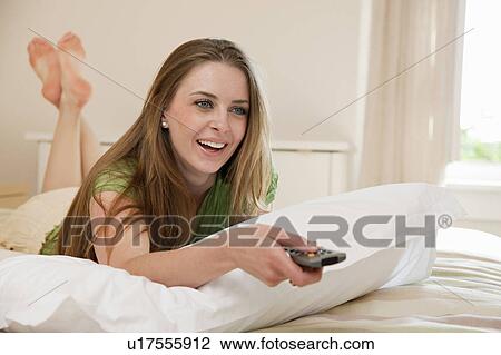 Woman in hotel room watching TV View Large Photo Image Stock Image - Woman in hotel room watching TV. Fotosearch
