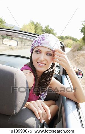 Stock Photography - Woman in the front seat of a convertible. Fotosearch
