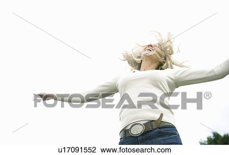 Stock Image - Woman jumping with joy. Fotosearch