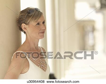 Stock Photo - Woman leaning against pillars. Fotosearch