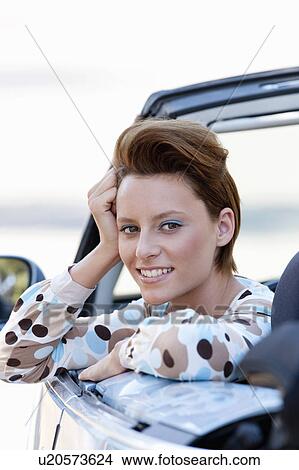 Picture - Woman leaning out of car window. Fotosearch