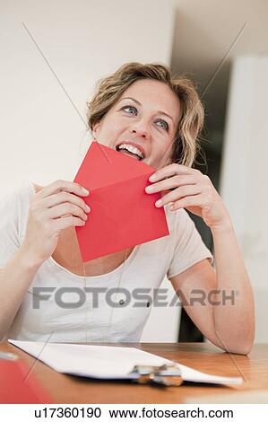Woman licking on red envelope View Large Photo Image Stock Image - Woman licking on red envelope. Fotosearch