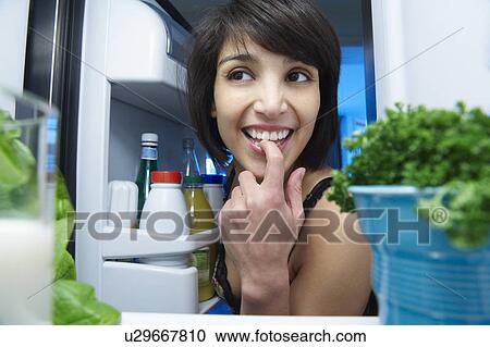 Woman looking in the fridge View Large Photo Image Stock Image - Woman looking in the fridge. Fotosearch