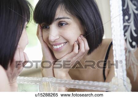 Stock Photography - Woman looking in the mirror. Fotosearch