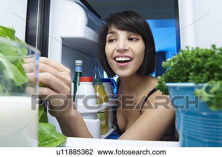 Woman looking into the fridge View Large Photo Image Stock Image - Woman looking into the fridge. Fotosearch